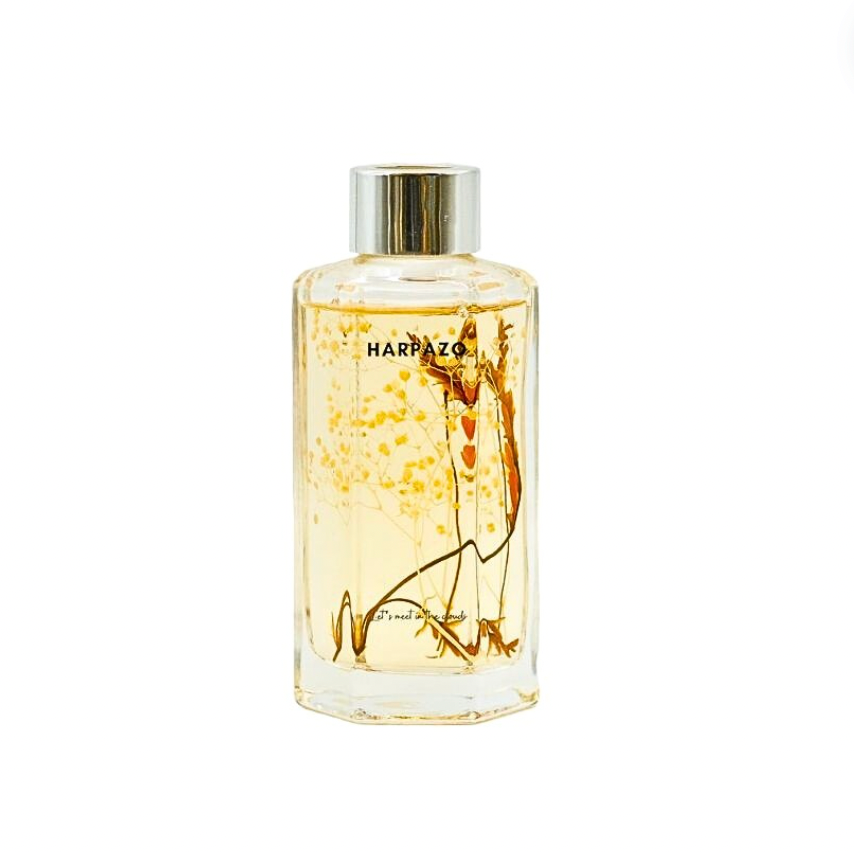 A clear glass reed diffuser bottle with a yellowish liquid.