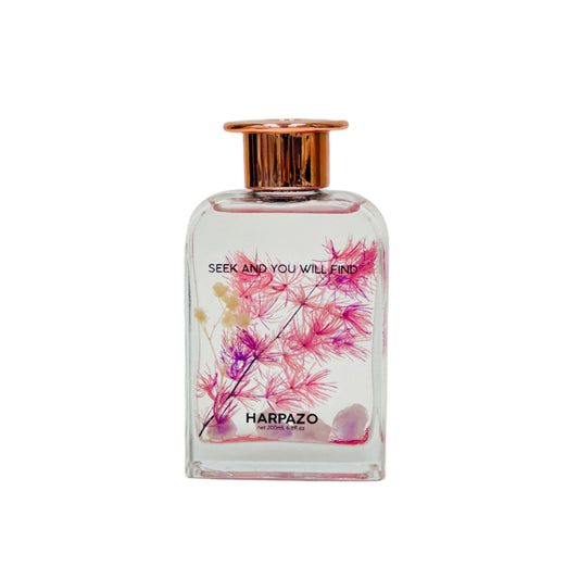 Perfume bottle with floral design and 'Harpazo' branding on a white background