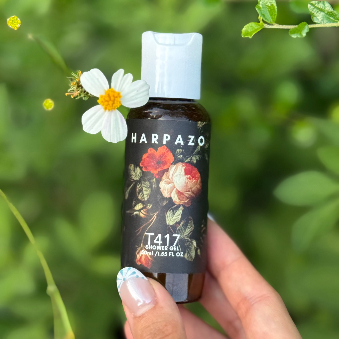 Harpazo T417 shower gel bottle held by a hand with a flower in front of a green leafy background