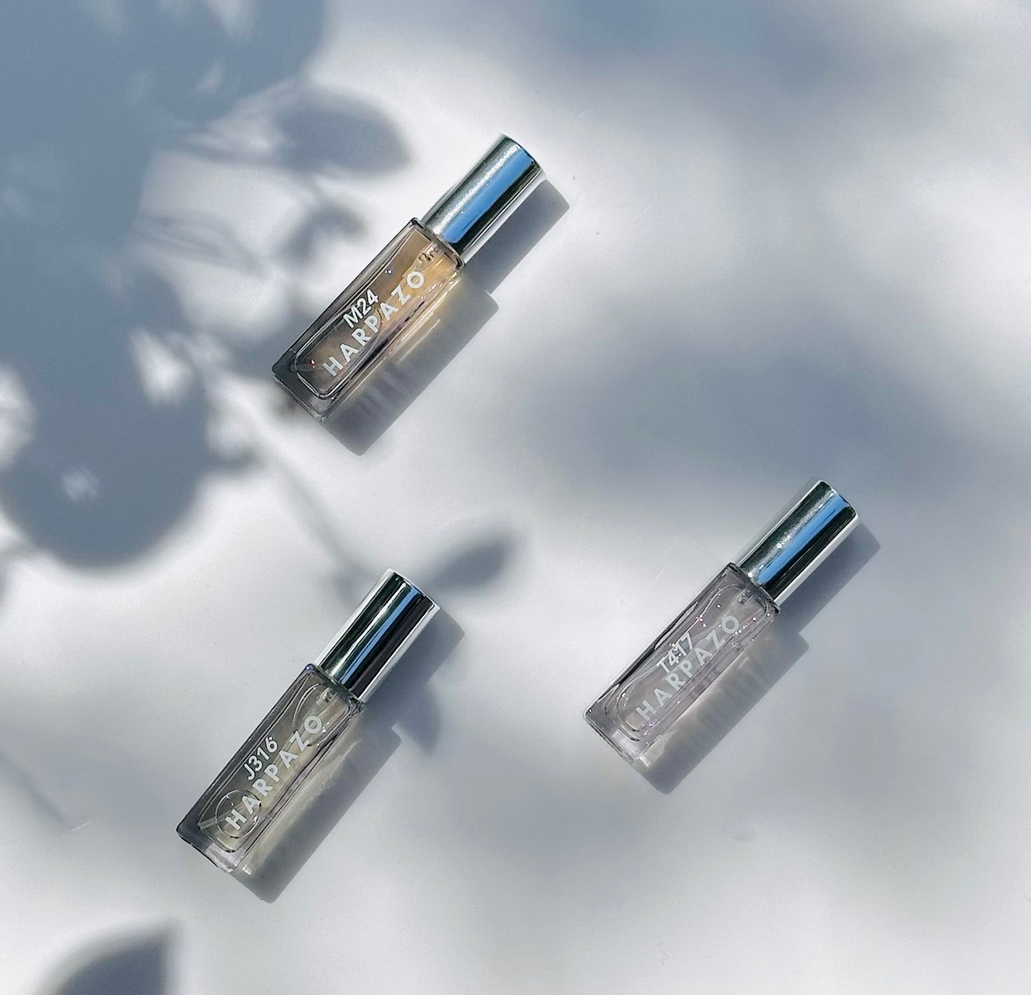 Three small bottles with metallic caps on a light background