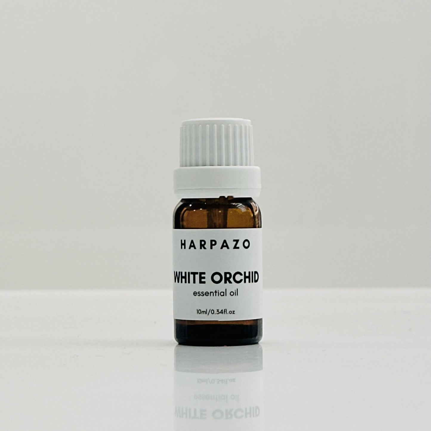 A small bottle labeled 'HARPAZO White Orchid essential oil 10ml' with a white cap, displayed against a light background.
