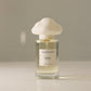 Perfume bottle with a white cap and visible label on a neutral background