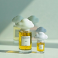 Two perfume bottles with cloud-shaped caps on a light background