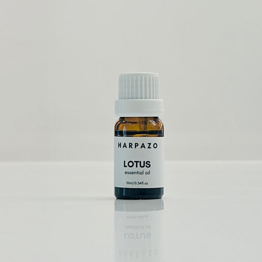 A small bottle labeled LOTUS essential oil on a light background.
