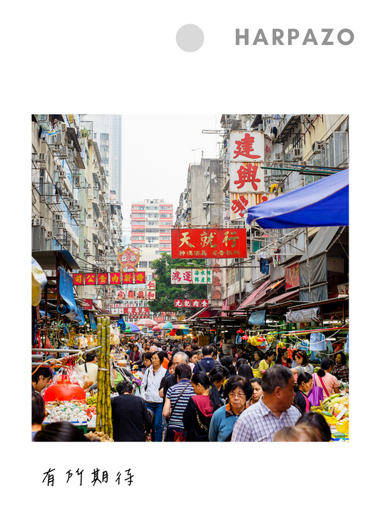 Crowded street market with people and colorful signs in an urban setting, featuring the brand 'HARPAZO'.