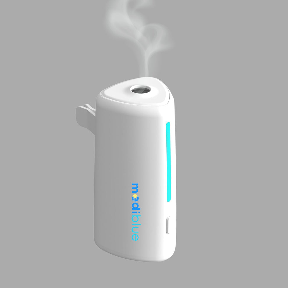 A white aromatic car diffuser with blue light indicators, emitting a cool mist, and displaying the brand name 'MediBlue'.