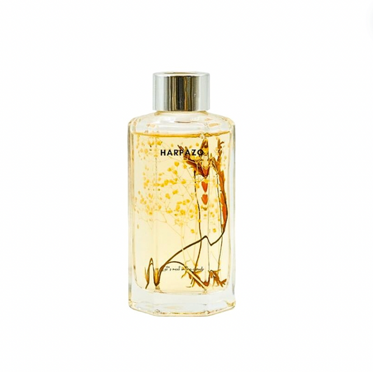 A clear glass reed diffuser bottle with a yellowish liquid.
