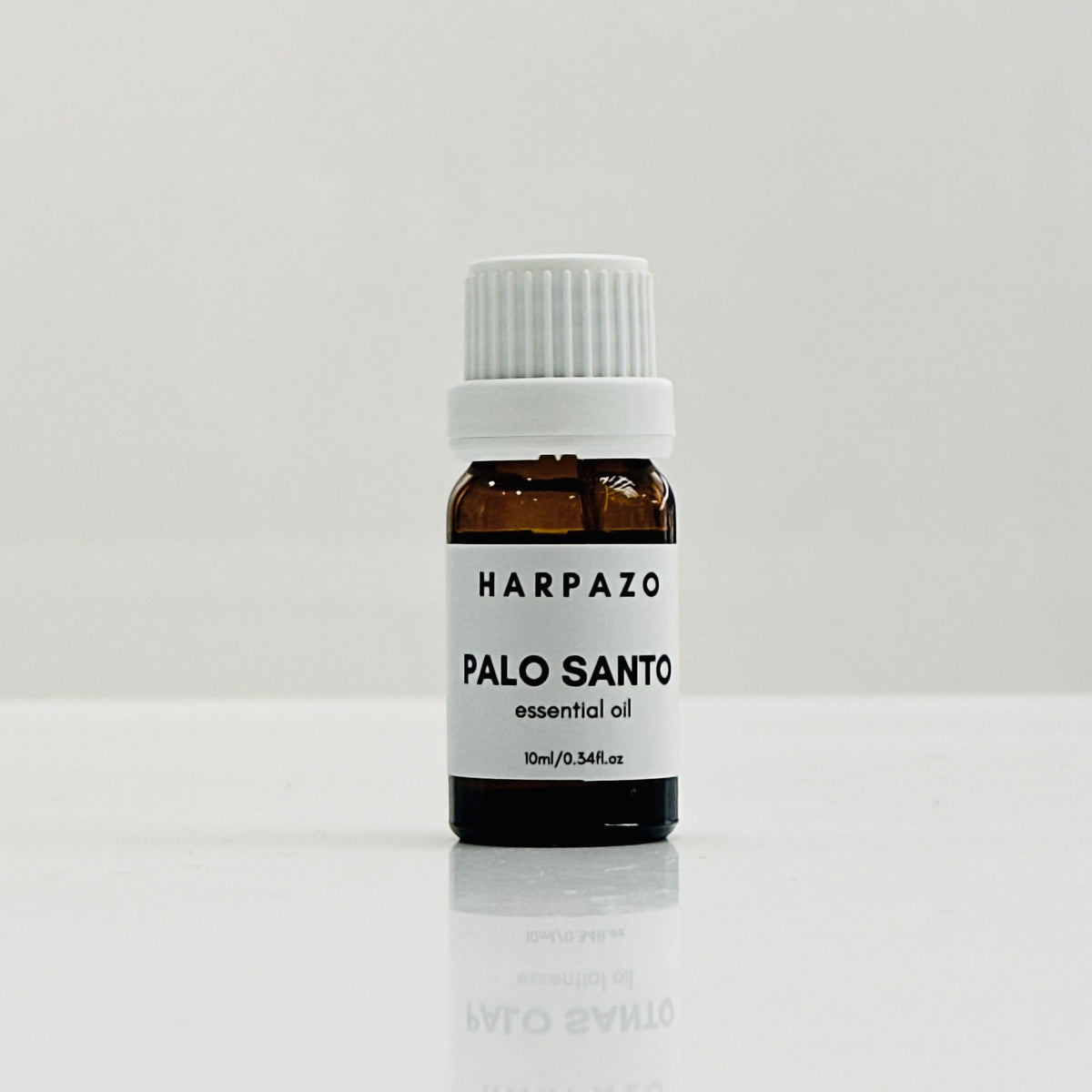 A small bottle labeled 'HARPAZO PALO SANTO essential oil 10ml' set against a white background.