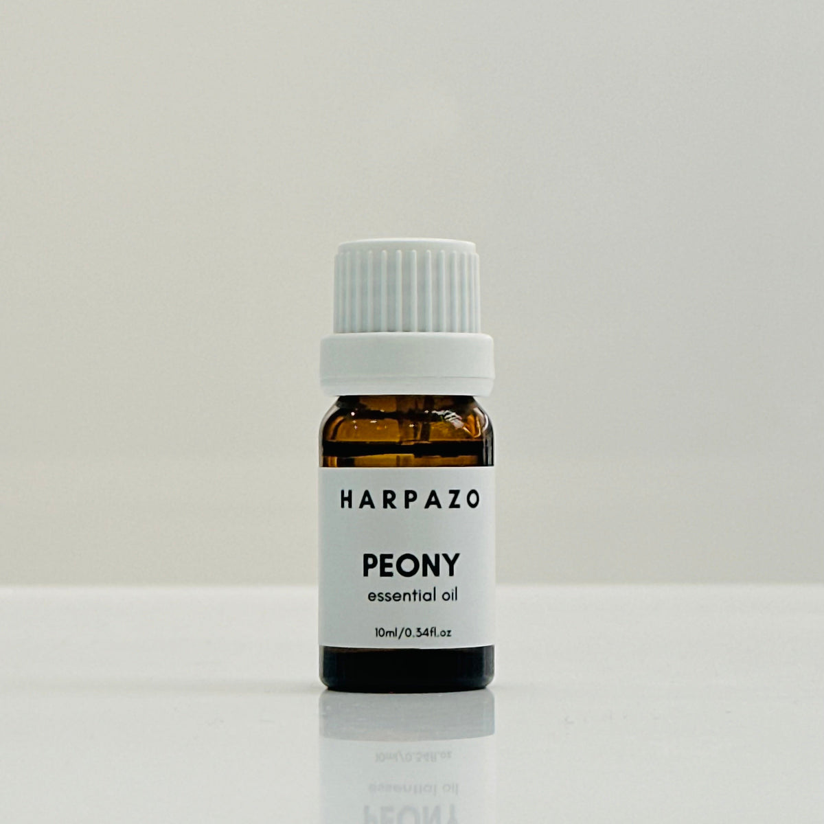 A small glass bottle labeled 'HARPAZO PEONY essential oil' with a white cap, containing 10ml of oil.