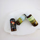 Three bottles of Harpazo products on a white stone surface