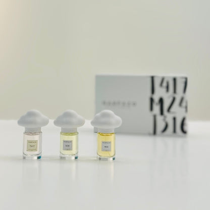Three glass bottles of perfume with unique cloud-shaped caps, labeled M24, J316, and T417, on a light background.