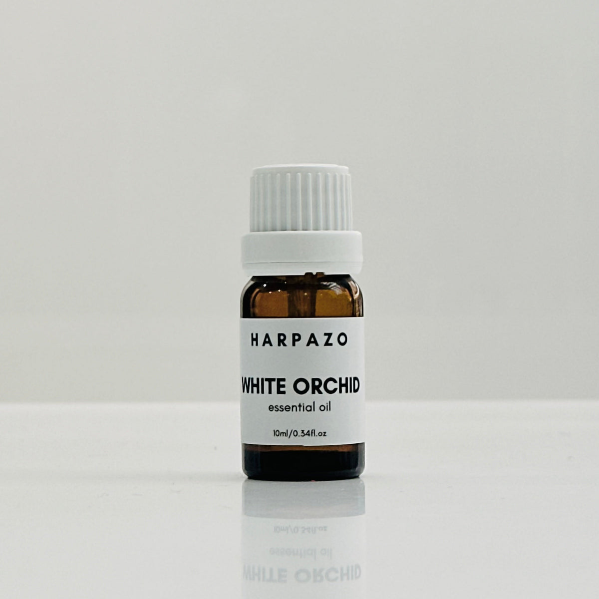 A small bottle labeled 'HARPAZO White Orchid essential oil 10ml' with a white cap, displayed against a light background.