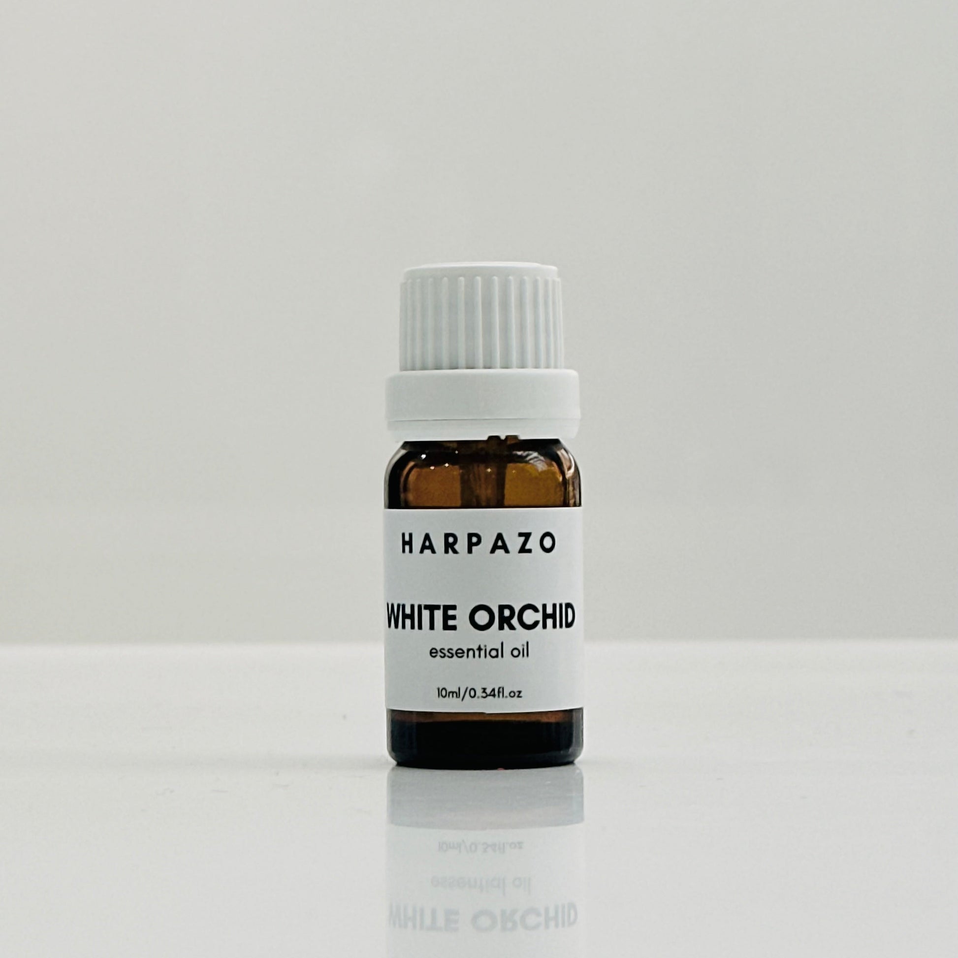 A small bottle labeled 'HARPAZO White Orchid essential oil 10ml' with a white cap, displayed against a light background.