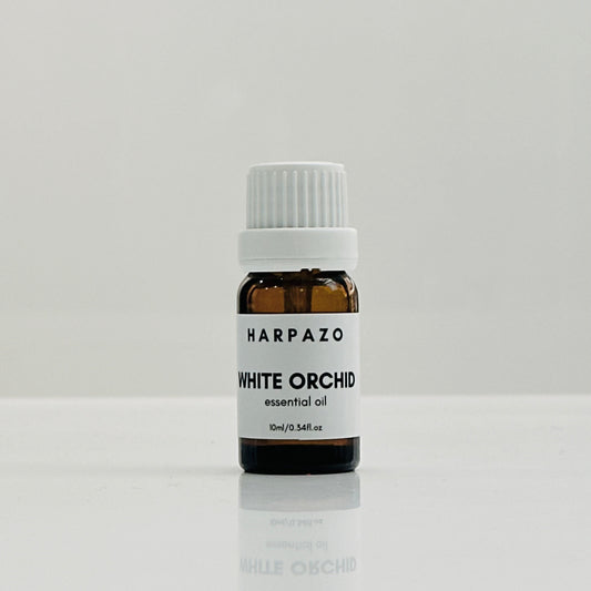 A small bottle labeled 'HARPAZO White Orchid essential oil 10ml' with a white cap, displayed against a light background.